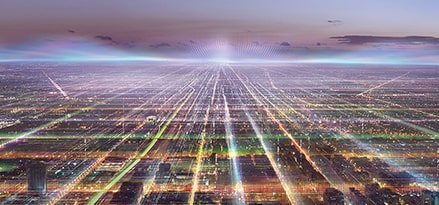 A panorama of a city at night, with a network of multicoloured lights