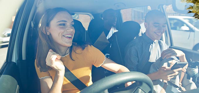 3 people smiling in a car