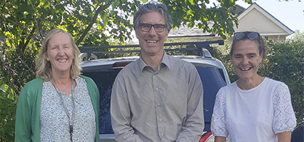 3 colleagues standing by a car