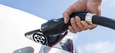 Man plugging in an EV to charge.