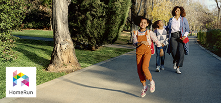 Woman walking with two girls in a park.